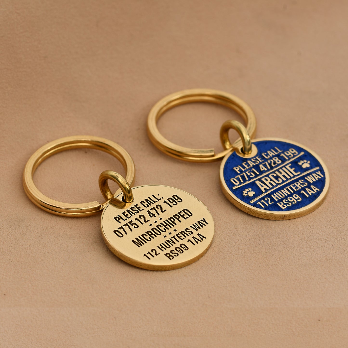 Brass round dog ID tag with deep engraving, handmade in the UK, shown on a collar for size reference.