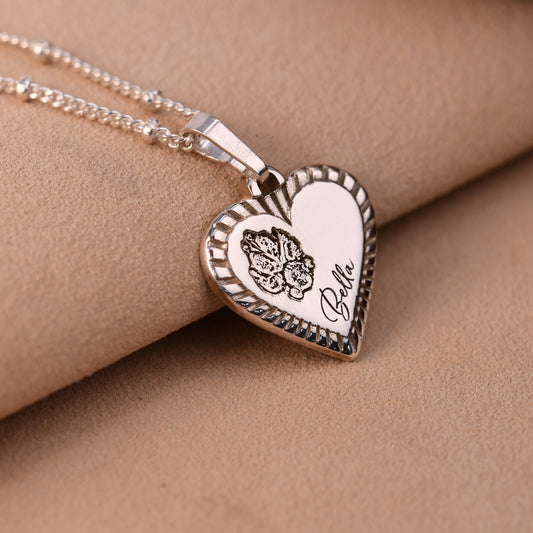 Heart-shaped pendant necklace on a person's neck against a beige background