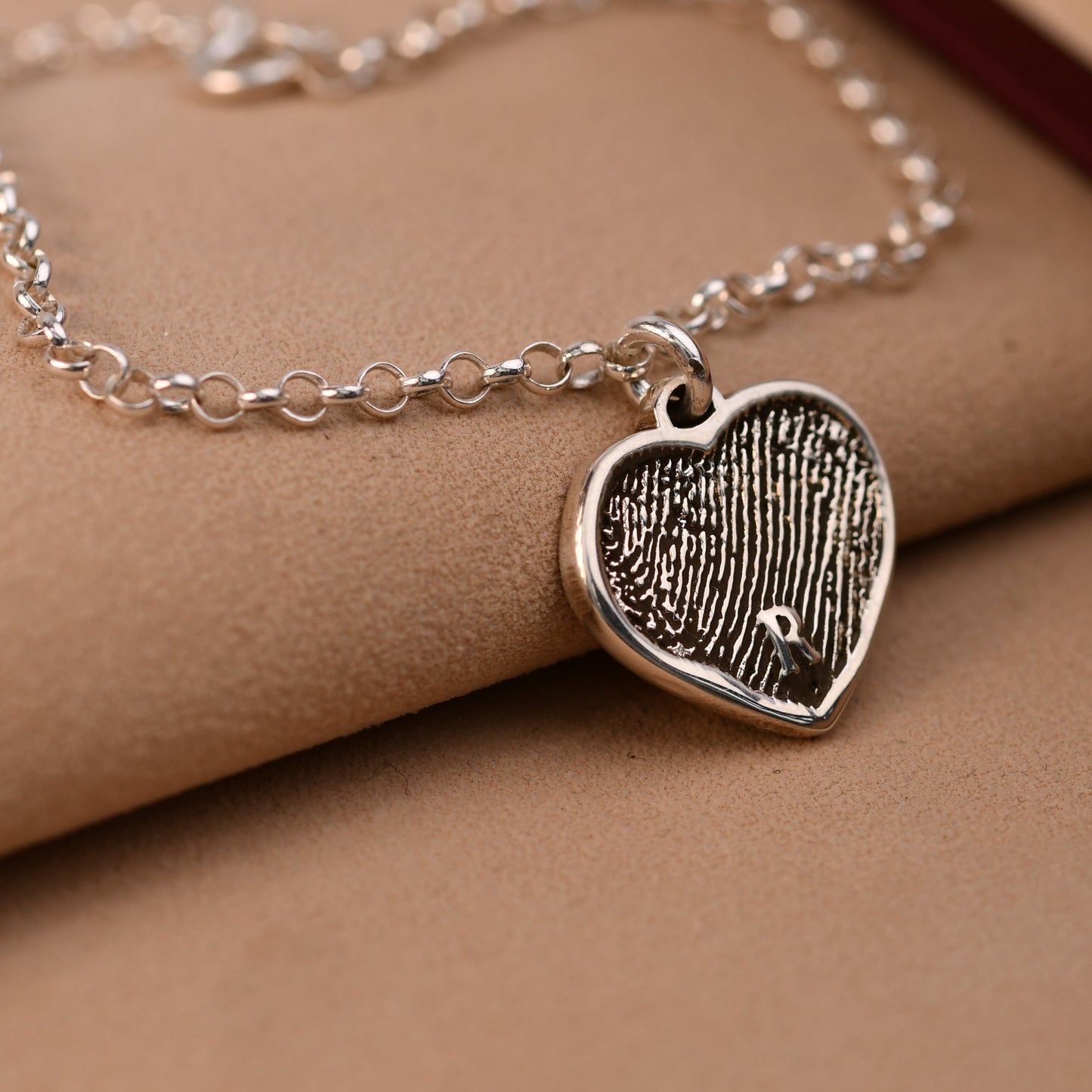 Artisan fingerprint heart bracelet with a half fingerprint and a name across the heart