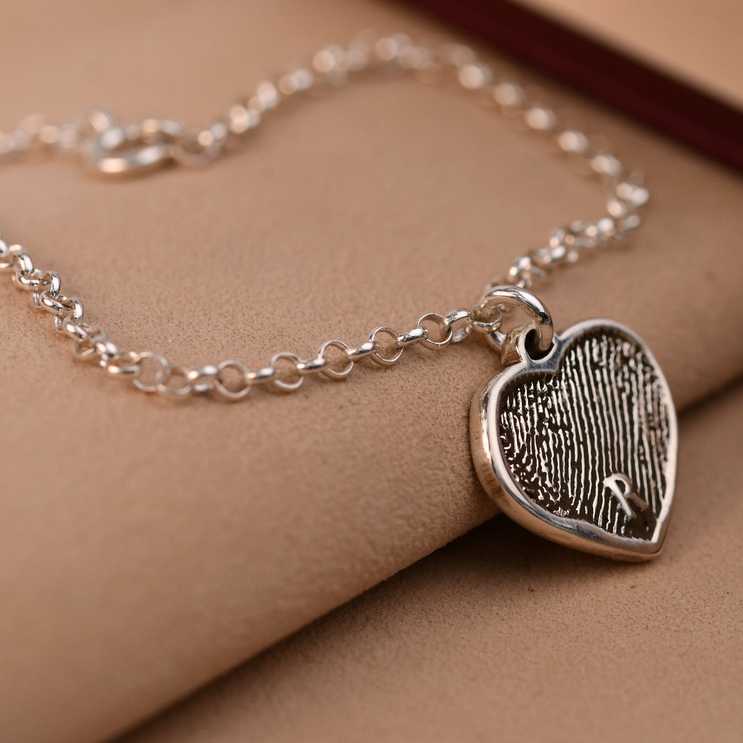 Artisan fingerprint heart bracelet in sterling silver, engraved with a full fingerprint and a small initial, on a rolo chain