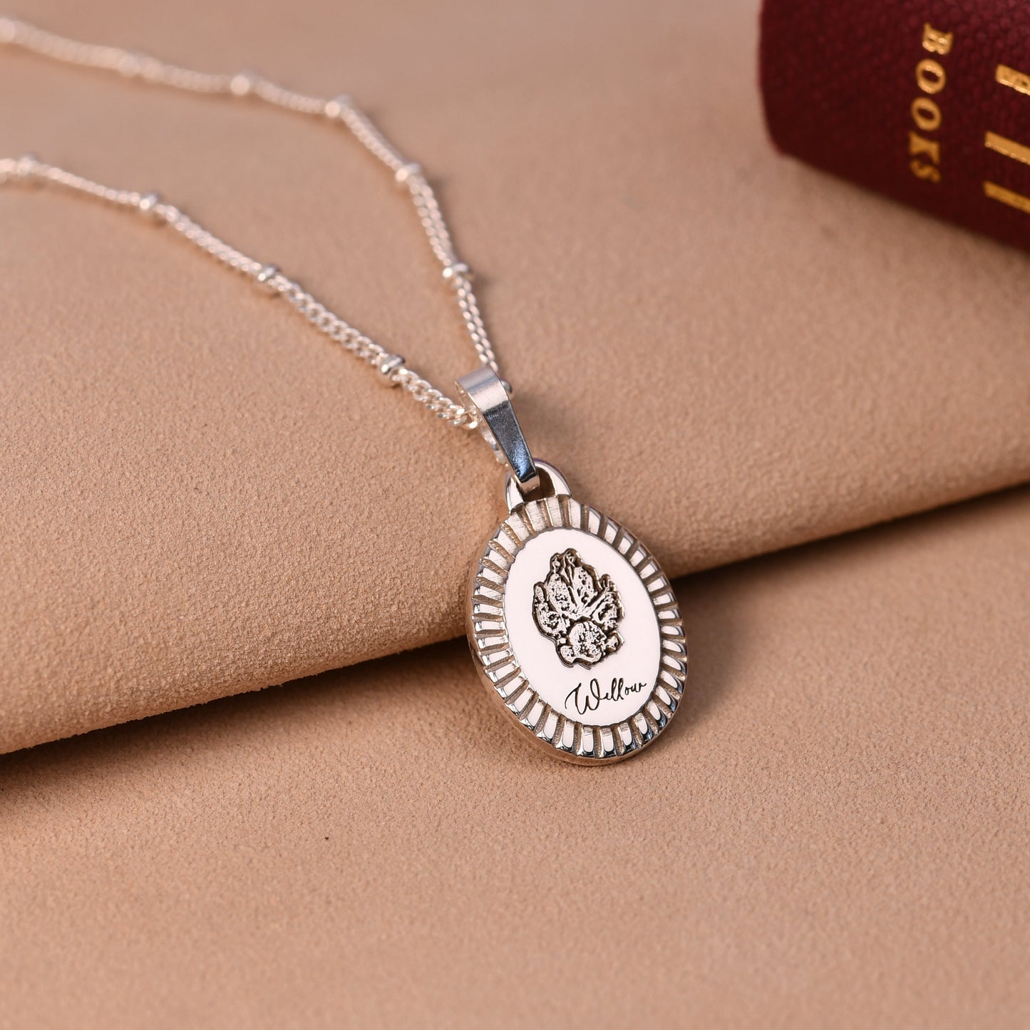 Silver necklace with a pendant on a beige surface
