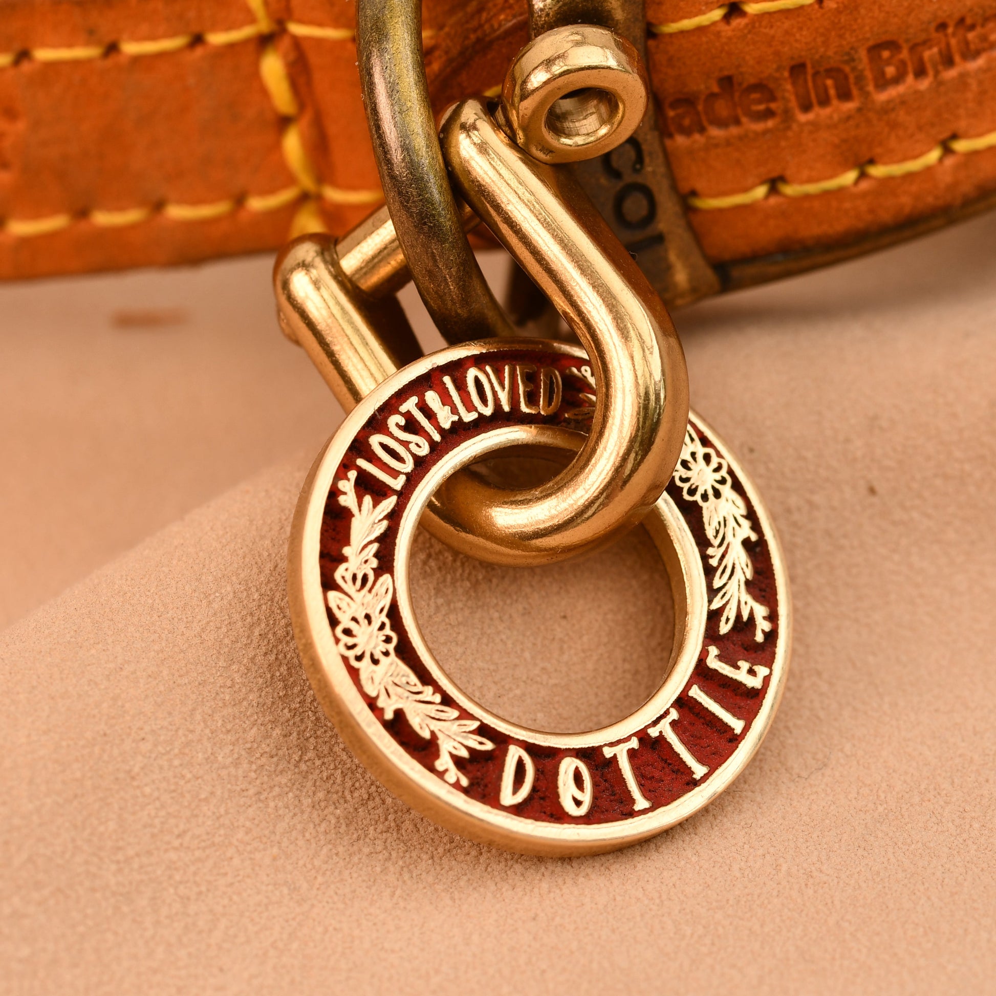 Close-up of a gold tag on a leather product with 'LOST & FOUND' engraved.