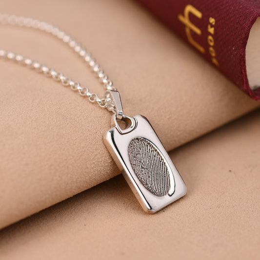 Fingerprint dog tag necklace in sterling silver with a heart bail and an engraved fingerprint