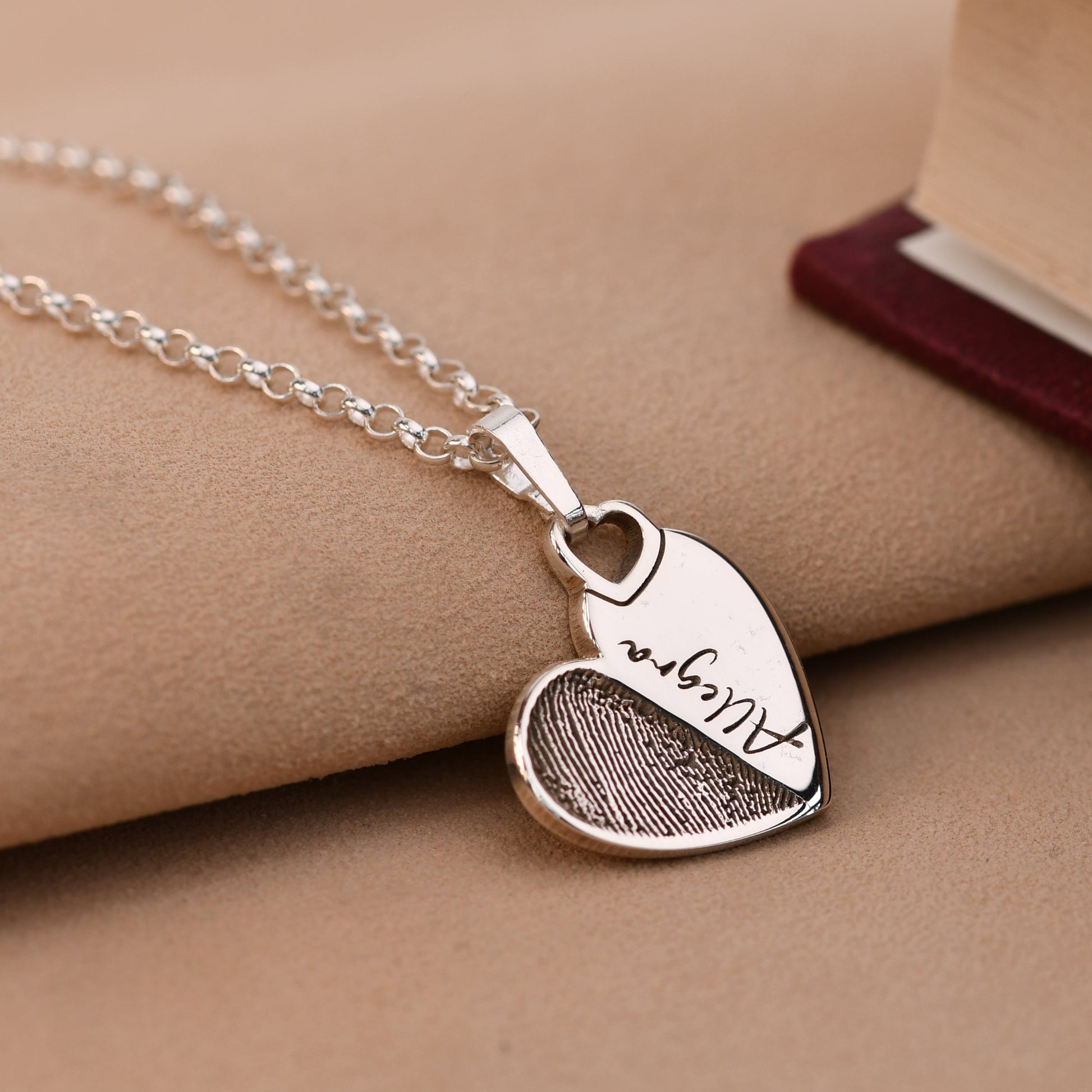 Sterling silver fingerprint heart necklace with a half fingerprint and a name across the heart