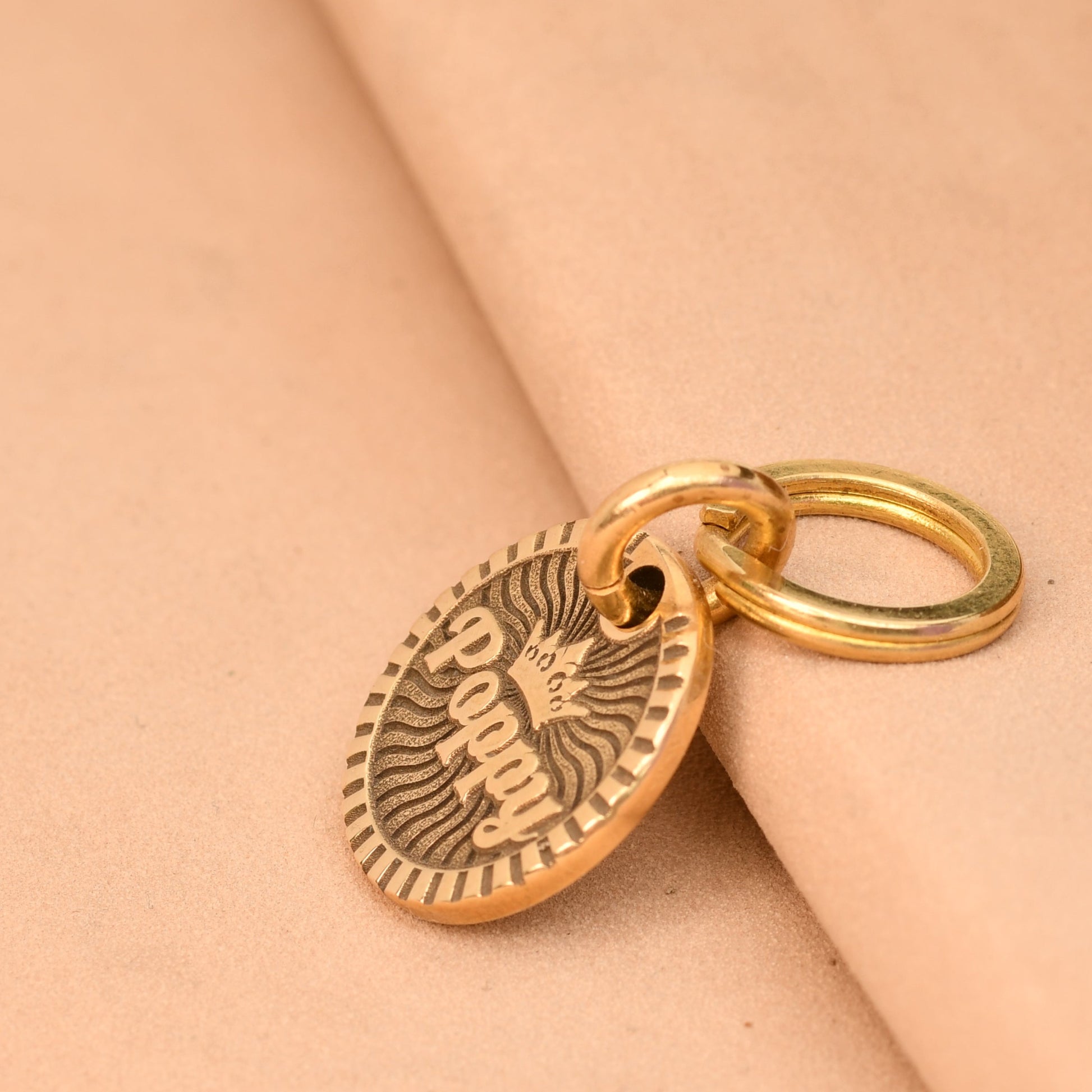 Gold charm on a beige fabric background