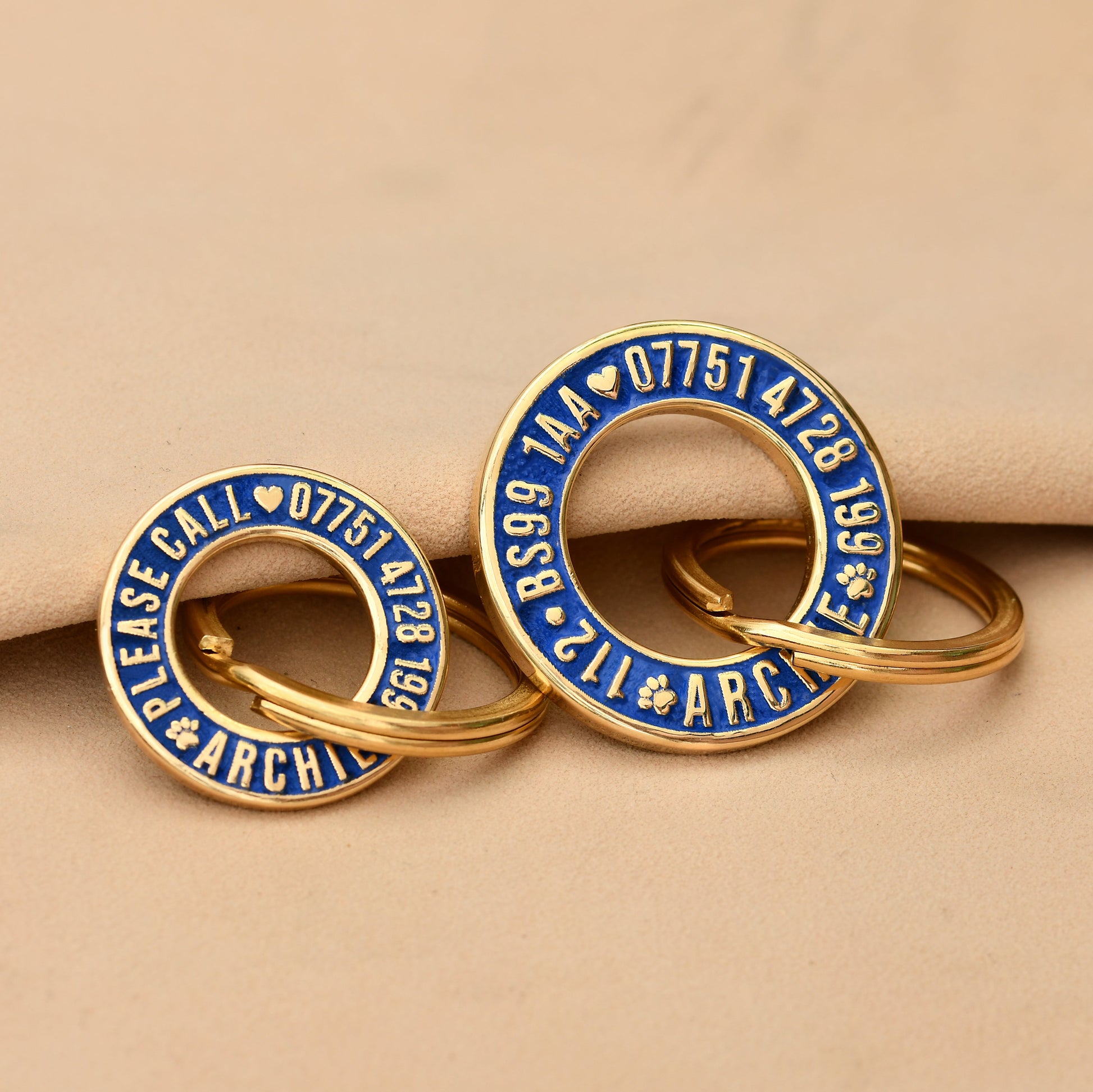 Hoop-shaped brass ID tag with deep custom engraving, handmade in the UK. Suitable for dogs, cats, and horse bridles, shown attached to a collar for display.