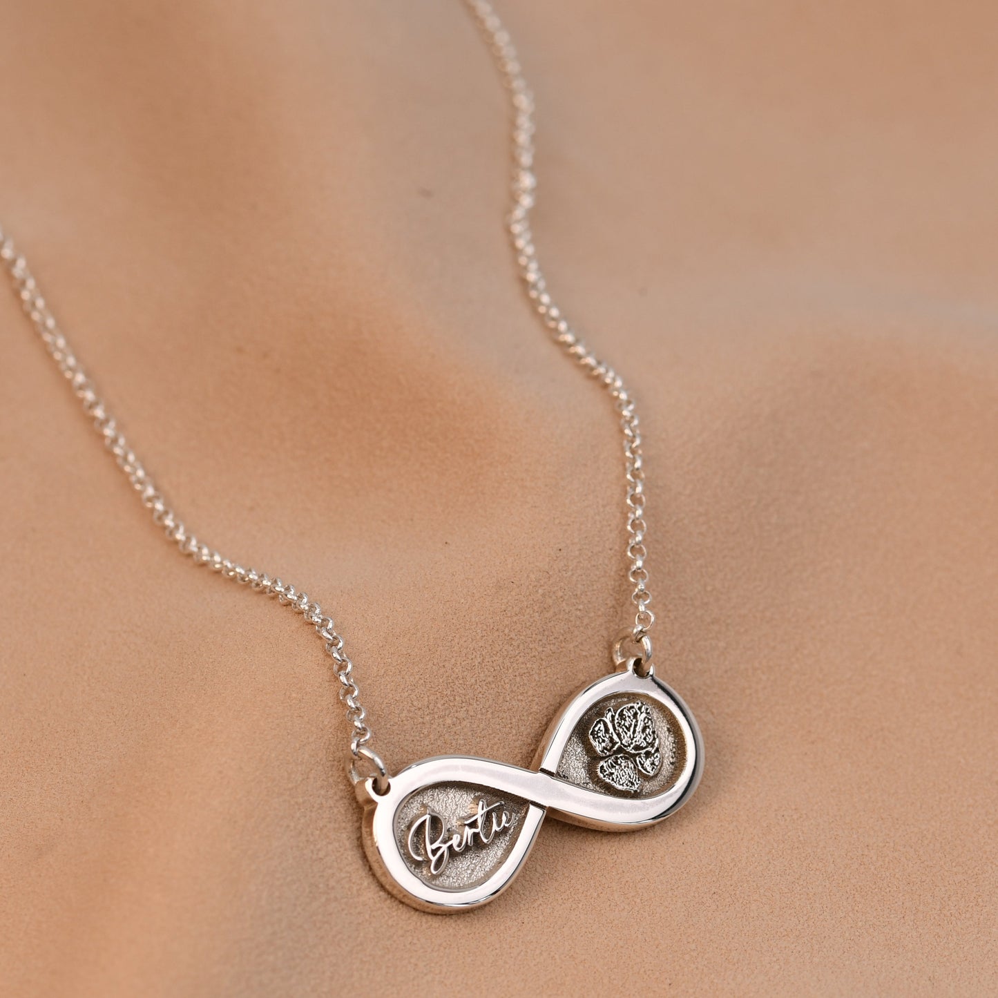 Silver necklace with interlocking circles on a beige background