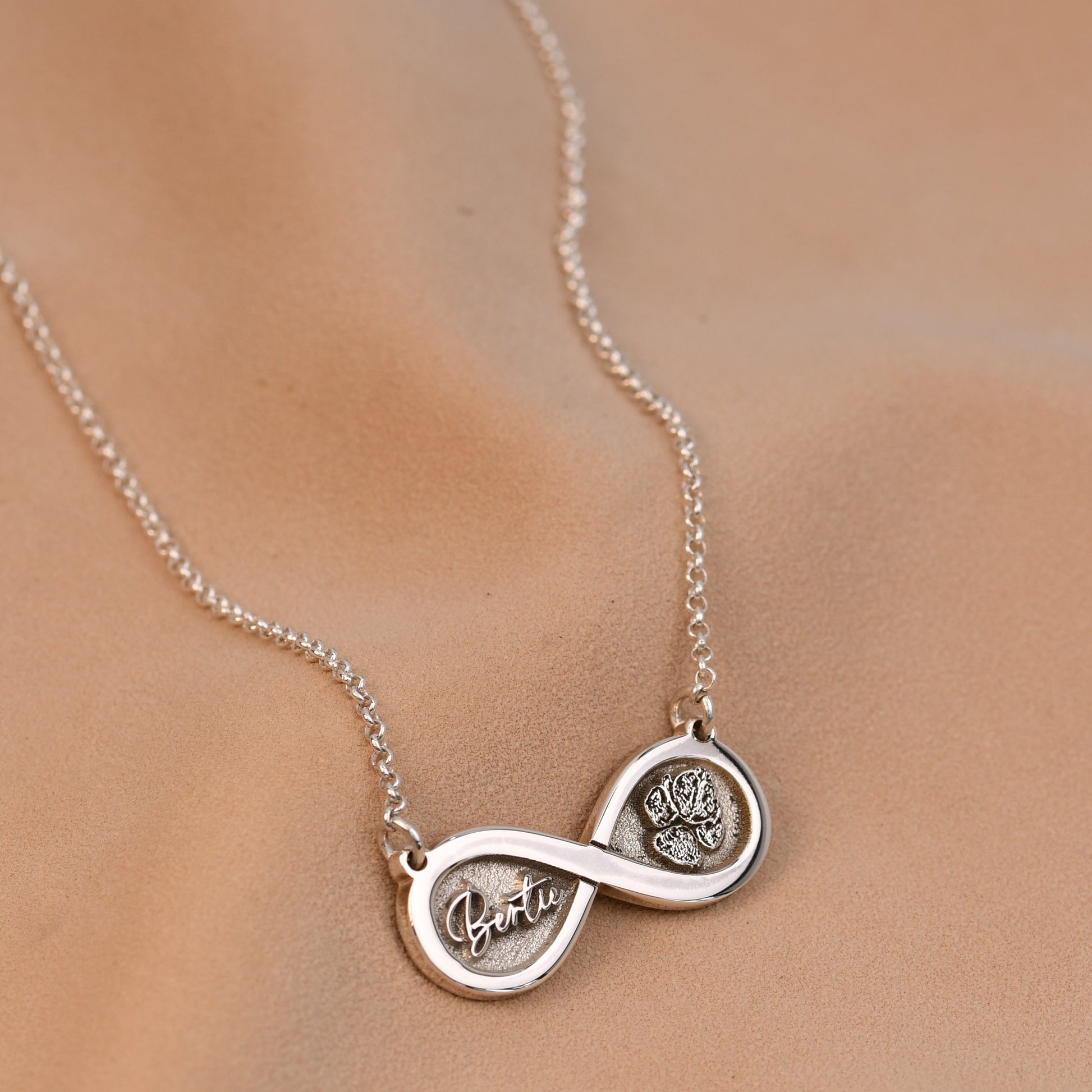 Silver necklace with interlocking circles on a beige background