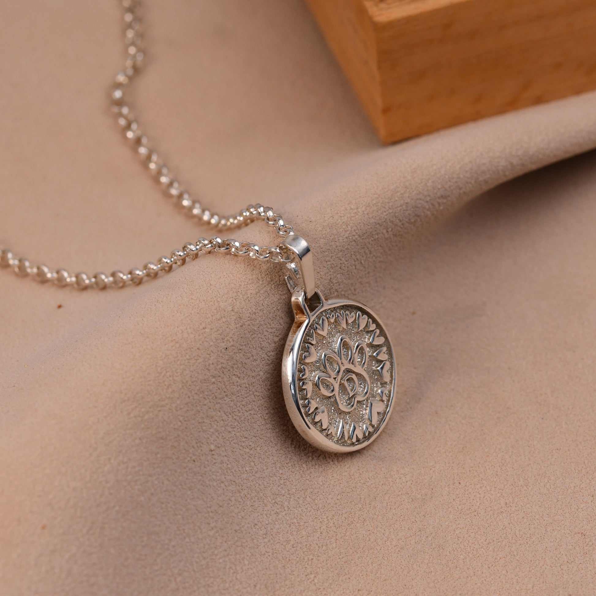 Silver necklace with a pendant on a beige surface