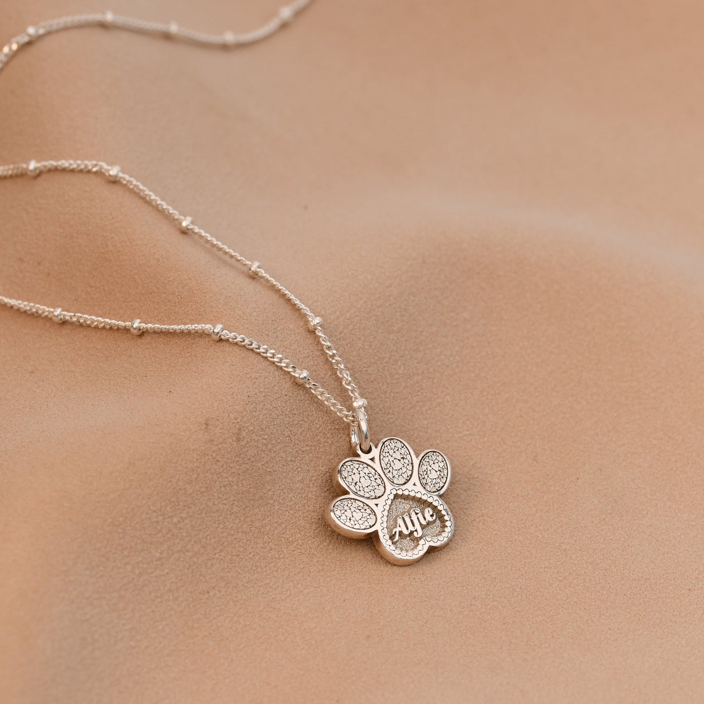 Silver necklace with a flower pendant on a skin background