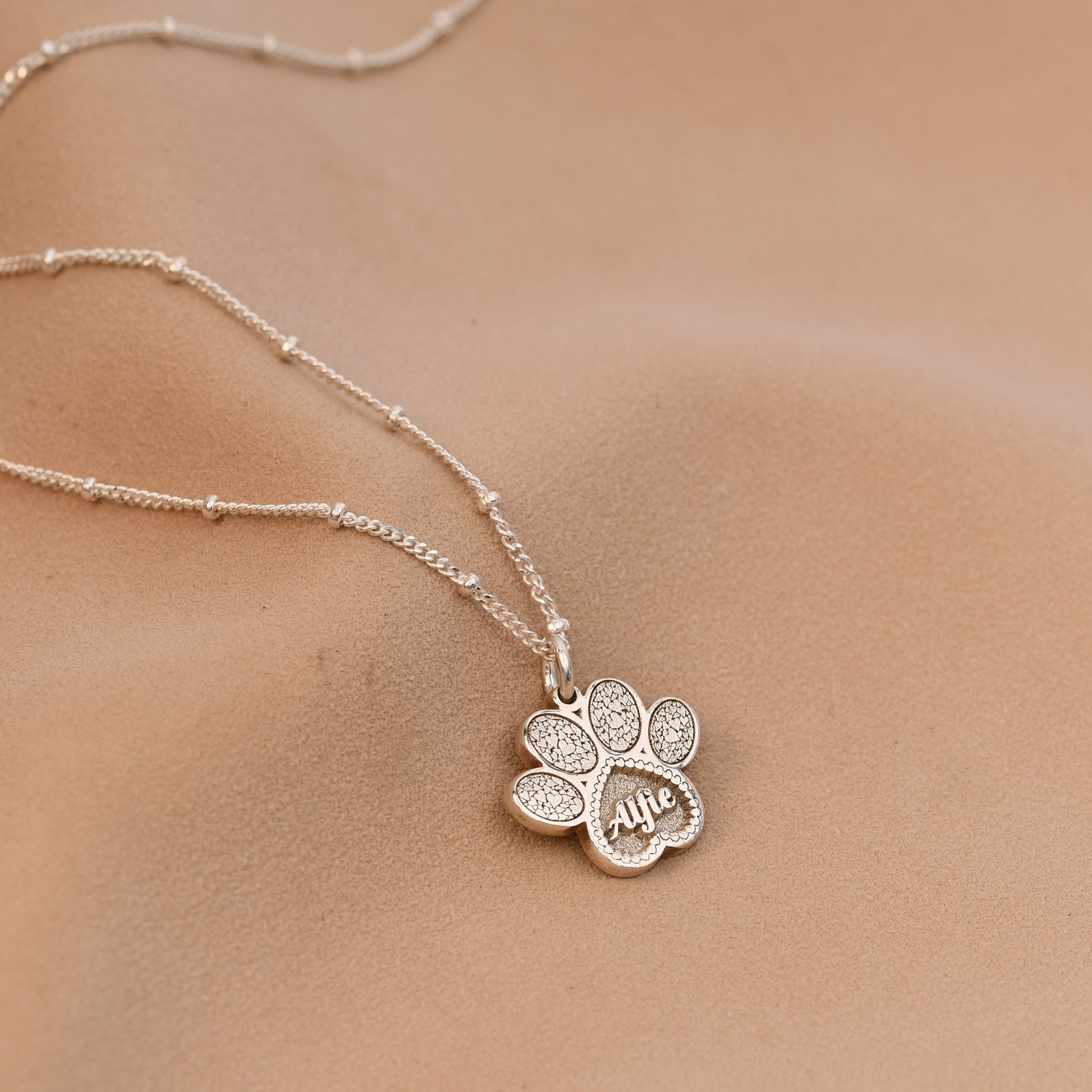 Silver necklace with a flower pendant on a skin background
