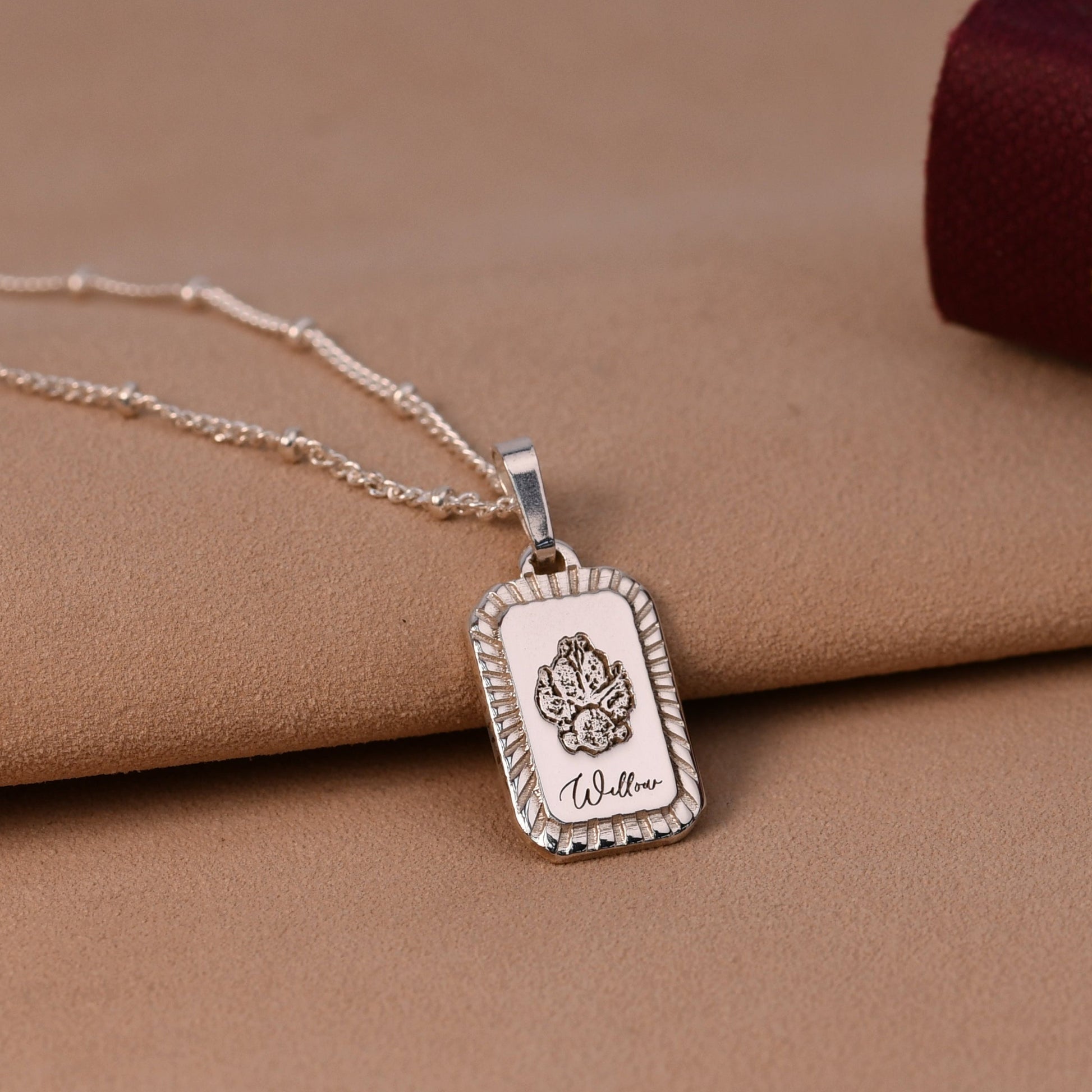 Silver necklace with a pendant on a brown surface